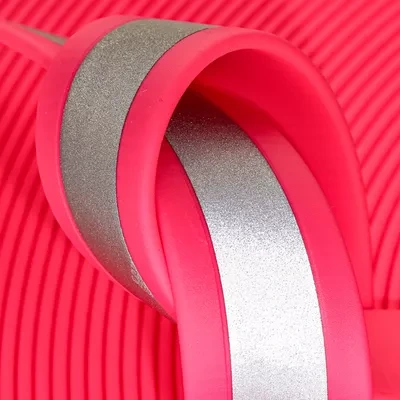 Close-up of Velocity Pink reflective BioThane. Vibrant neon pink woven with reflective strands for a high-fashion, high-performance safety collar.