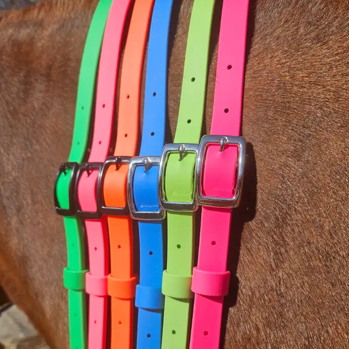 Five handcrafted BioThane® horse neck straps in vivid neon green, orange, blue, yellow, and pink displayed on a horse’s back. Each adjustable horse neck strap features a sturdy silver buckle and adjustable holes. Waterproof, stink-proof, and durable, designed for horse riders, offering bold style and practical performance for active equines and their owners in East Sussex.