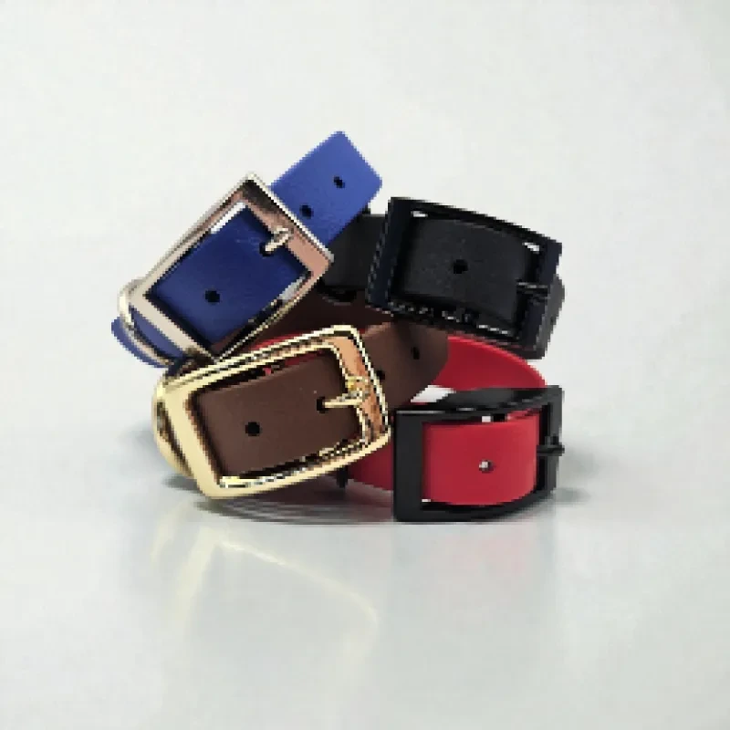 Four handcrafted BioThane® dog collars in blue, black, brown, and red, each featuring sturdy metal hardware in gold or black. Waterproof, stink-proof, and easy to clean, these bespoke collars combine durability with vibrant colour choices, showcasing the quality and style of Ponies &amp; Pups’ made-to-order gear.