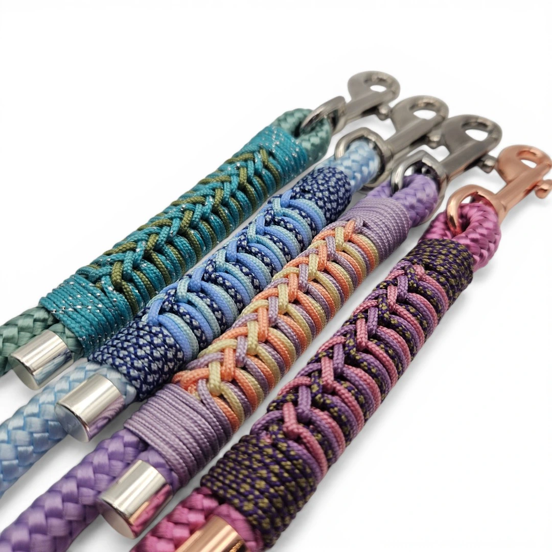Four handcrafted dog leads in pastel and rainbow tones, featuring unique decorative hand-braiding with contrasting ropes. Each lead is finished with sturdy metal and rose gold snap clips, polished end caps, and is made from waterproof BioThane®. Designed for durability, easy cleaning, and standout bespoke style.